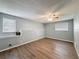 Spacious bedroom featuring wood-look floors, a ceiling fan, and windows for natural light at 7119 Lenape Cir, New Port Richey, FL 34653