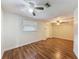 Bright bedroom featuring hardwood floors, ceiling fan, and a window with blinds at 7119 Lenape Cir, New Port Richey, FL 34653