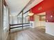 Dining room with red accent wall, wood floors, and modern lighting fixture at 7119 Lenape Cir, New Port Richey, FL 34653