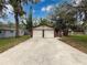 A long driveway leads to a charming house with a two-car garage and mature trees at 7119 Lenape Cir, New Port Richey, FL 34653