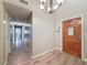 Spacious foyer with wood-look floors and a decorative light fixture, leading to other rooms at 7119 Lenape Cir, New Port Richey, FL 34653