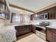 Kitchen with granite countertops, stainless steel appliances and dark wood cabinets at 7119 Lenape Cir, New Port Richey, FL 34653