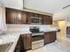 View of kitchen featuring stainless steel appliances, dark cabinets and breakfast bar at 7119 Lenape Cir, New Port Richey, FL 34653