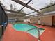 Enclosed pool area with clear water, surrounded by an orange deck and screened enclosure at 7119 Lenape Cir, New Port Richey, FL 34653