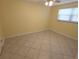 This bedroom features neutral walls, tile flooring, and a ceiling fan at 7313 Hatteras Dr, Hudson, FL 34667