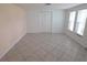 Bright and spacious bedroom with tiled floors, a closet with double doors, and a view from the windows at 7313 Hatteras Dr, Hudson, FL 34667