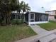Charming home featuring a screened-in porch and lush tropical landscaping, creating a private outdoor space at 7313 Hatteras Dr, Hudson, FL 34667