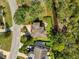 An aerial view of a private residence surrounded by lush greenery, highlighting the home's unique roof and outdoor space at 7340 Brightwaters Ct, New Port Richey, FL 34652