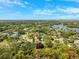 Aerial view of a home within a lush, green neighborhood near a lake at 7340 Brightwaters Ct, New Port Richey, FL 34652