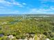 Wide aerial perspective of a coastal neighborhood with waterways and abundant vegetation under a clear, blue sky at 7340 Brightwaters Ct, New Port Richey, FL 34652