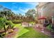 Spacious backyard featuring a patio, fire pit, lush landscaping, and plenty of room to entertain at 7340 Brightwaters Ct, New Port Richey, FL 34652