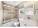 Bright bathroom featuring a shower-over-tub setup, complemented by a modern sink and a window for natural light at 7340 Brightwaters Ct, New Port Richey, FL 34652