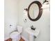 Powder room features a pedestal sink with an oval mirror and decorative sconces at 7340 Brightwaters Ct, New Port Richey, FL 34652