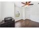 Clean, simple room featuring hardwood flooring, a ceiling fan and a charming arched window with a lovely view at 7340 Brightwaters Ct, New Port Richey, FL 34652