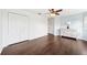 Bedroom with dark wood floors, white walls, a ceiling fan, and a double-door closet at 7340 Brightwaters Ct, New Port Richey, FL 34652