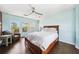 Bright bedroom with a ceiling fan and multiple windows providing natural light and backyard views at 7340 Brightwaters Ct, New Port Richey, FL 34652