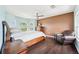 Spacious bedroom featuring wood-look floors, arched windows, and a comfortable leather chair at 7340 Brightwaters Ct, New Port Richey, FL 34652