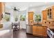 Bright kitchen features light wood cabinets, stainless steel appliances, mosaic backsplash, and dining nook with wooded view at 7340 Brightwaters Ct, New Port Richey, FL 34652