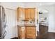 Kitchen area with light wood cabinets, granite countertop, mosaic backsplash, and stainless steel refrigerator at 7340 Brightwaters Ct, New Port Richey, FL 34652