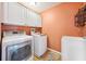 A functional laundry area equipped with a washing machine, dryer, utility sink, and overhead cabinets at 7340 Brightwaters Ct, New Port Richey, FL 34652