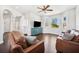Large living room with hardwood floors, bright natural light, and a decorative ceiling fan at 7340 Brightwaters Ct, New Port Richey, FL 34652