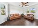 Bright living room features hardwood floors and lots of natural light and a modern ceiling fan at 7340 Brightwaters Ct, New Port Richey, FL 34652