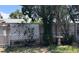 Fenced backyard with mature trees and a decorative bird bath, offering a private outdoor space at 7534 Briarwood Dr, Port Richey, FL 34668