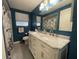 Modern bathroom with a double sink vanity, marble countertop, and blue accent walls at 7534 Briarwood Dr, Port Richey, FL 34668