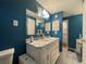 Bathroom with double vanity sink, marble countertops, and blue accent walls at 7534 Briarwood Dr, Port Richey, FL 34668