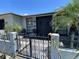 Inviting front entrance with a decorative gate, tiled patio, potted plants and a pair of chairs at 7534 Briarwood Dr, Port Richey, FL 34668