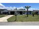 Charming home featuring an inviting front yard with lush greenery and a palm tree, creating a tropical ambiance at 7534 Briarwood Dr, Port Richey, FL 34668