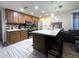 Kitchen with stainless appliances, eat-in island and plenty of cabinets provides view to living room at 7534 Briarwood Dr, Port Richey, FL 34668