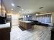 Open kitchen with center island, stainless appliances, and wood cabinets overlooks the living room at 7534 Briarwood Dr, Port Richey, FL 34668
