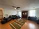 Spacious living room features hardwood floors, a ceiling fan, and bright natural light at 7534 Briarwood Dr, Port Richey, FL 34668