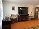 Cozy living room with hardwood floors, a fireplace, a large TV, and a grandfather clock at 7534 Briarwood Dr, Port Richey, FL 34668