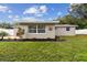 Backyard landscaping with flower beds, mature trees, and white privacy fence at 7545 Banner St, New Port Richey, FL 34653