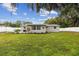 Backyard landscaping with flower beds, mature trees, and white privacy fence at 7545 Banner St, New Port Richey, FL 34653