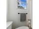 Bathroom featuring a toilet, towel rack, and window for natural light at 7545 Banner St, New Port Richey, FL 34653