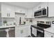 The kitchen features white cabinets, modern stainless steel appliances, and white quartz countertops at 7545 Banner St, New Port Richey, FL 34653