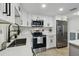 Well-lit kitchen features white cabinetry, modern stainless steel appliances, and white quartz countertops at 7545 Banner St, New Port Richey, FL 34653