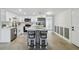 Modern kitchen features white cabinets, stainless steel appliances, a large island, and two barstools at 7545 Banner St, New Port Richey, FL 34653