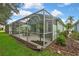 A view of the backyard and screened patio with an umbrella table and seating at 8149 Ambersweet Pl, Land O Lakes, FL 34637