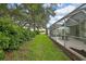 An expansive backyard featuring a screened-in patio, lush greenery, and well-manicured lawn at 8149 Ambersweet Pl, Land O Lakes, FL 34637