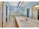 Bright bathroom features a double sink vanity, glass enclosed shower, and blue walls at 8149 Ambersweet Pl, Land O Lakes, FL 34637