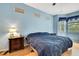 Comfortable bedroom featuring light blue walls and light-colored wood floors at 8149 Ambersweet Pl, Land O Lakes, FL 34637