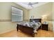 Bedroom features a dark wood bed frame and side table, and wood flooring at 8149 Ambersweet Pl, Land O Lakes, FL 34637