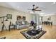 Cozy living room with hardwood floors, ceiling fan, and an open view of the dining area at 8149 Ambersweet Pl, Land O Lakes, FL 34637