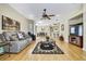 Large living room with hardwood floors, fan, and an open view of the dining area and kitchen at 8149 Ambersweet Pl, Land O Lakes, FL 34637