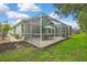 A screened patio with an umbrella table and seating, and a meticulously maintained lawn at 8149 Ambersweet Pl, Land O Lakes, FL 34637