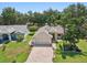 Aerial view of a well-maintained home with lush landscaping, a brick driveway, and a two-car garage at 8248 Sugarbush Dr, Spring Hill, FL 34606